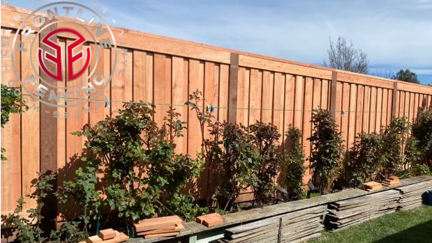 side angle of a fence with plants on the side of it