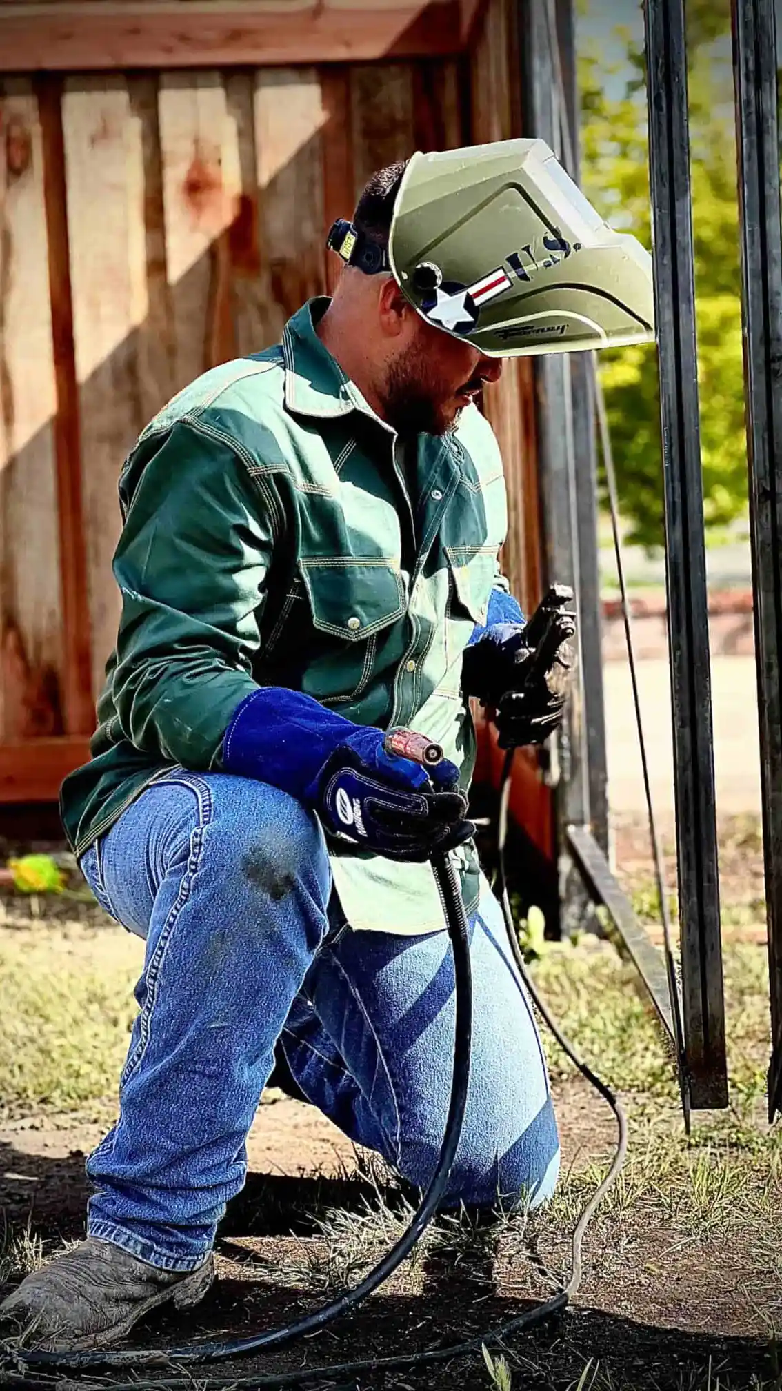 guy welding a metal frame on fence